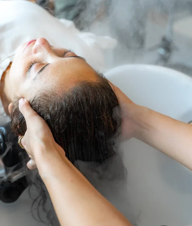 Massage du cuir chevelu à deux mains sous la brume tiède