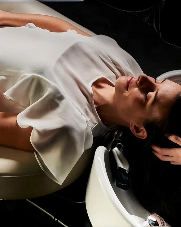 Massage du cuir chevelu sur le bac YUME, la cliente allongée à plat
